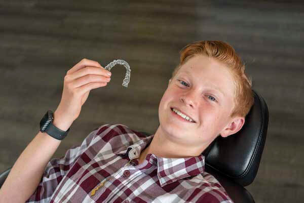boy holding clear aligners