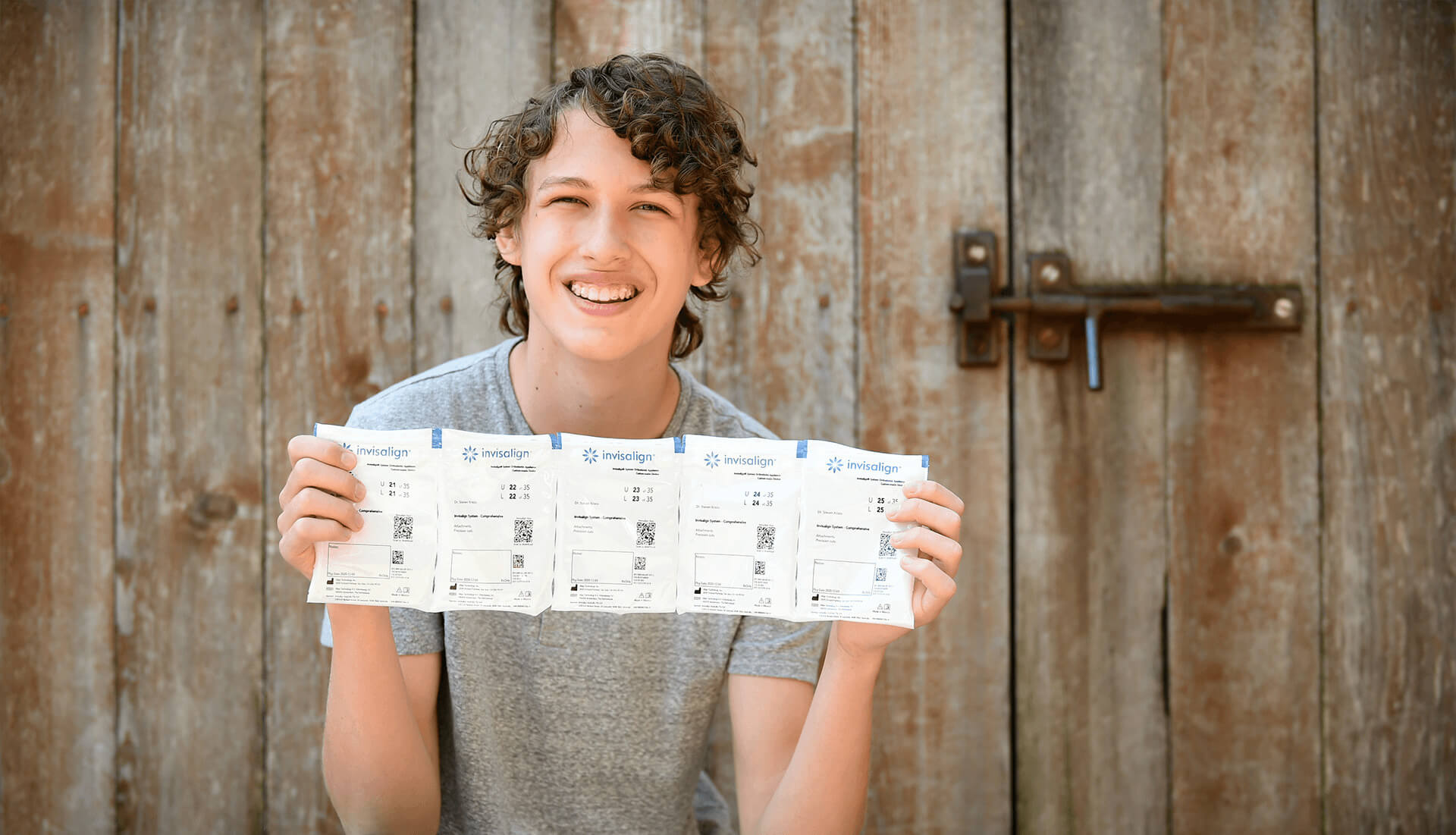 smiling boy holding aligners